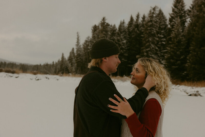 A man holding the face of his fiance as they are looking into each other's eyes. Shot by Judith Photo Co. engagement photographer..
