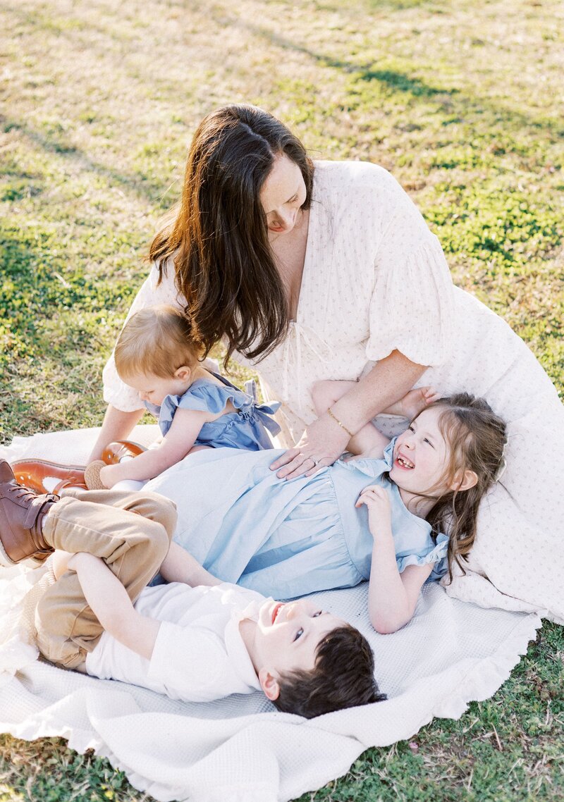 mom with kids laying on a blanket during peoria, illinois family photos 