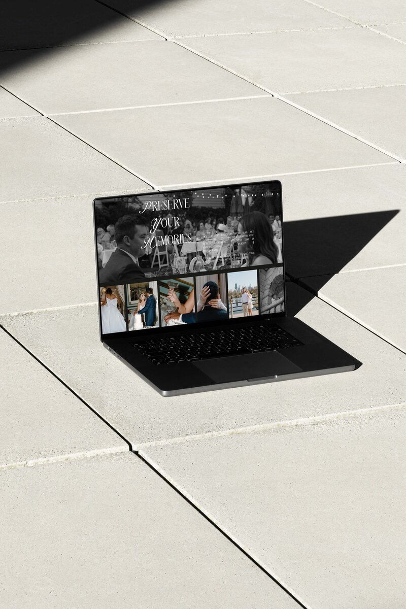 Laptop sitting on concrete for a visual mockup of a designed photography website 
