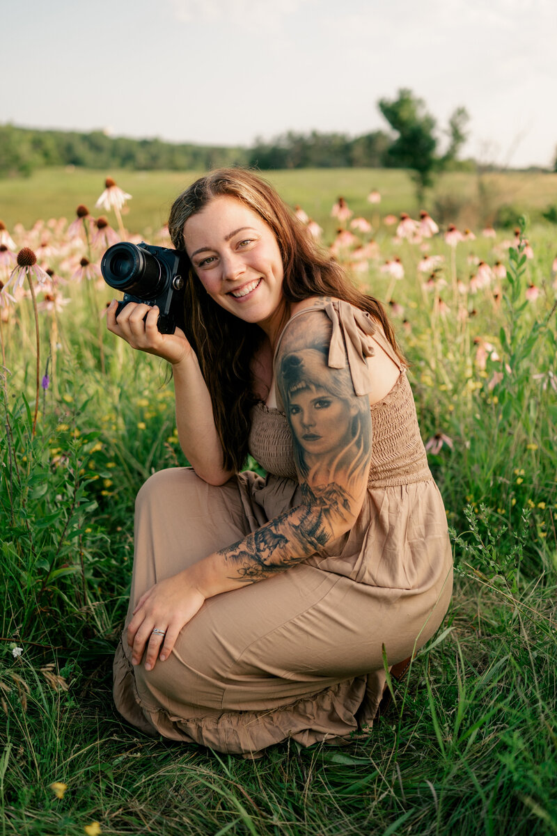 headshots portrait of photographer holding camera in a white wall studio