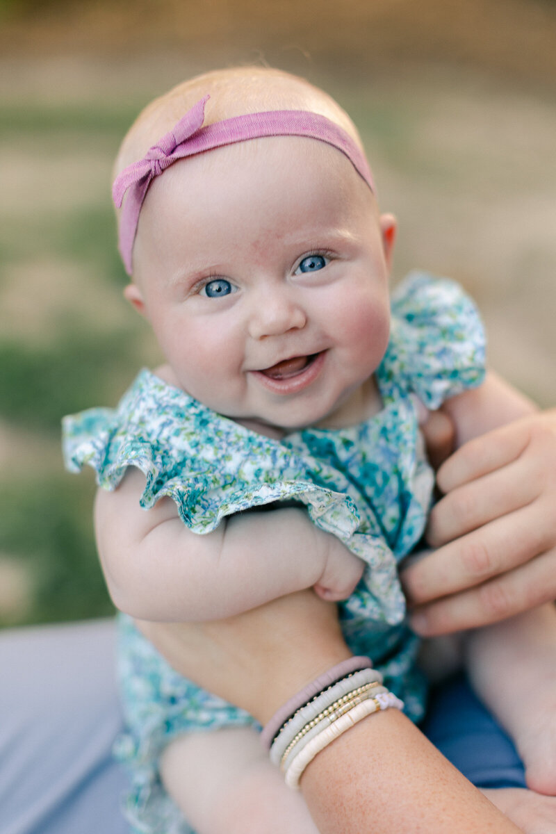 six month old baby smiling at camera