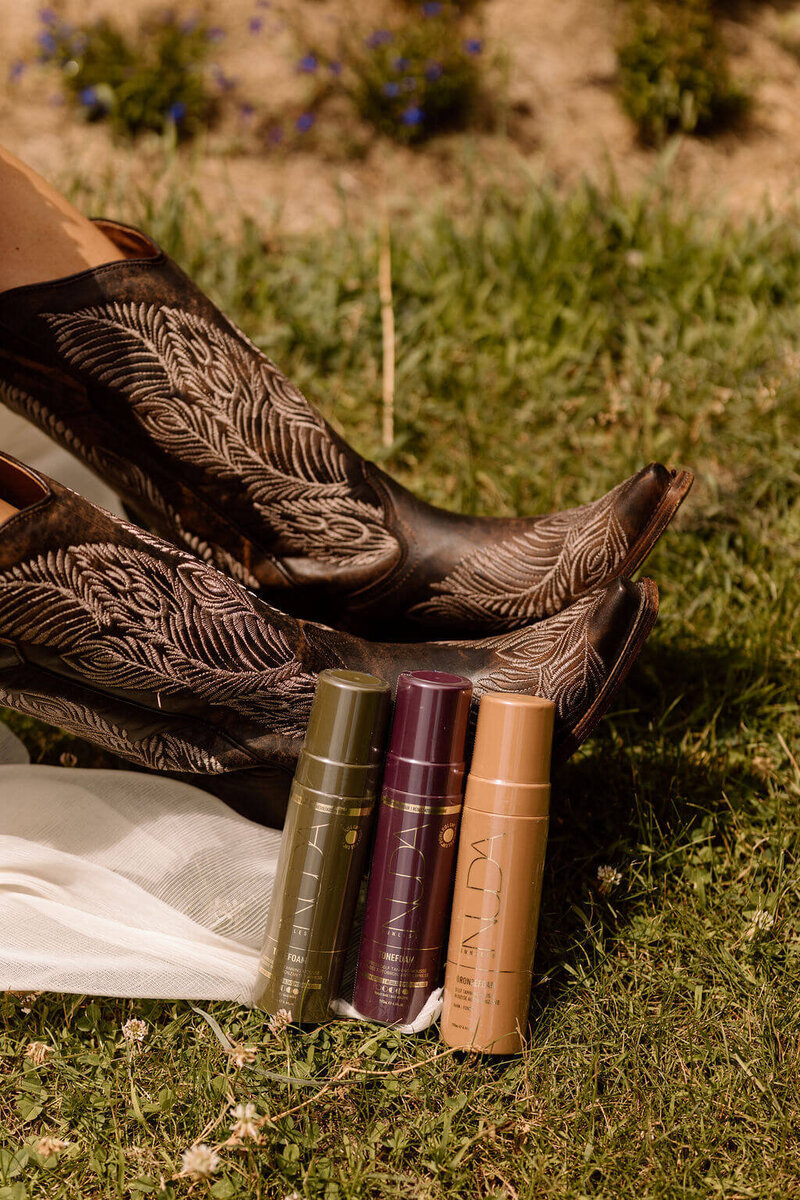 Nuda spray tan products and makeup brushes set up outdoors for a mobile spray tanning service by Boho Glow Studio.