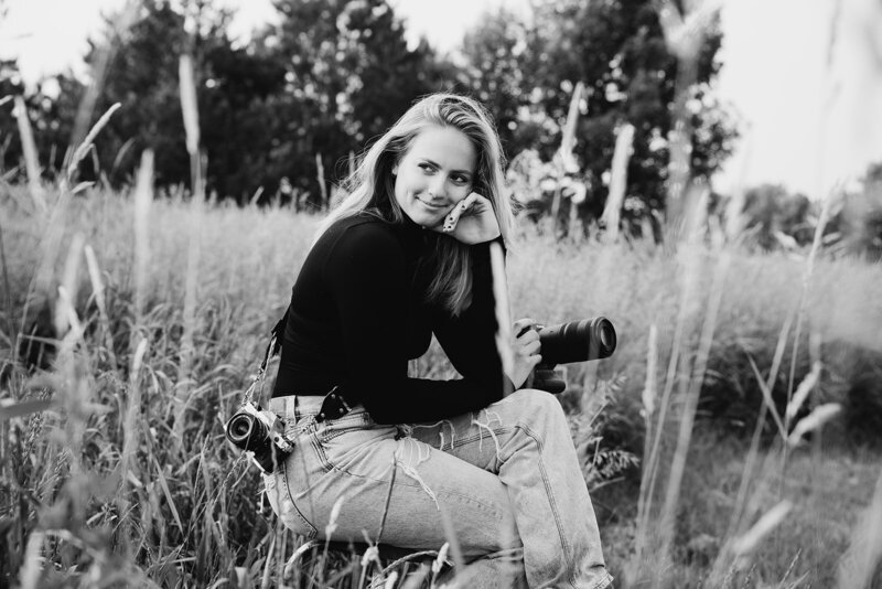 Caitlyn Kloeckl Photography sitting on wooden stool in the grass profile picture