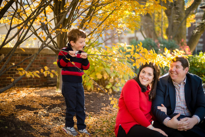 son holds onto branch being playful during family picture session
