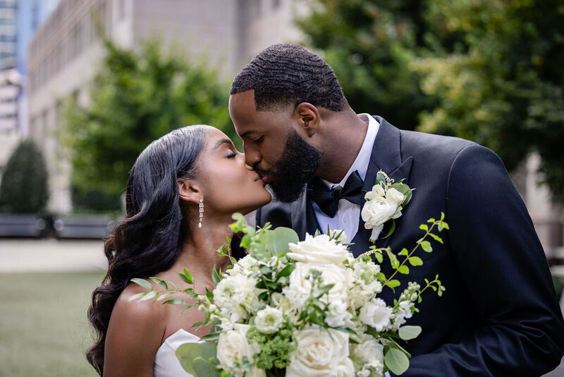 a couple kisses at the luxury charlotte wedding in the garden