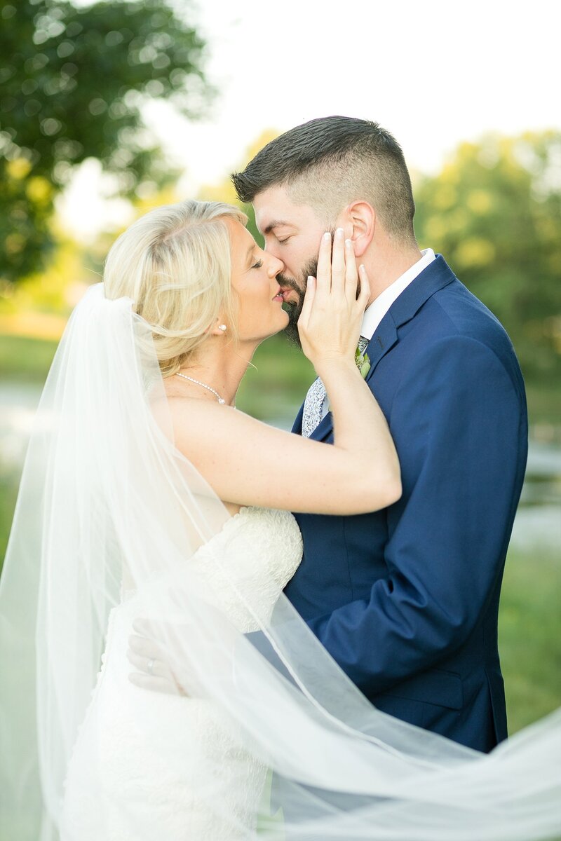 Bride and groom posing near a river outside