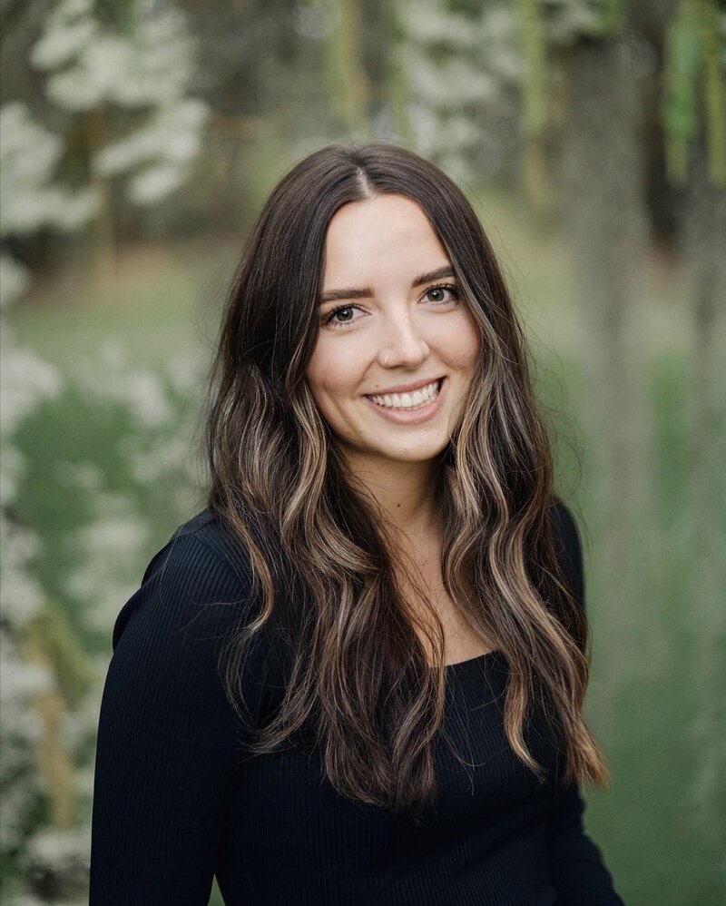 Woman posing for a photograph wile smiling.