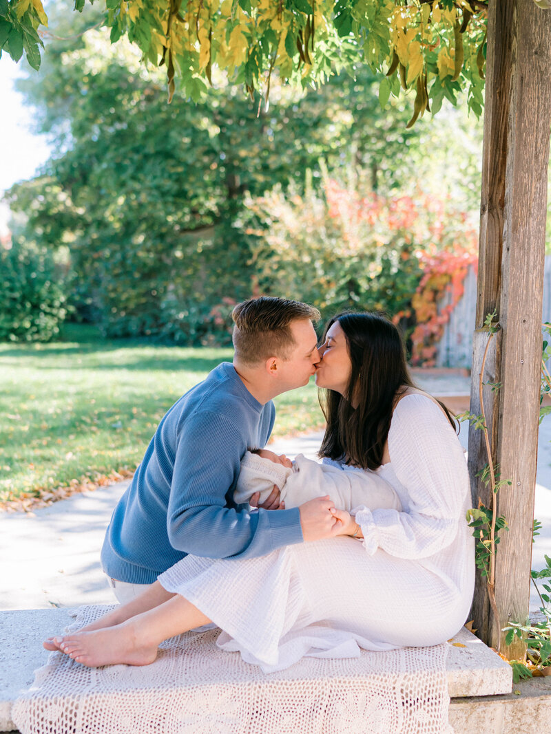 New parents admiring their baby  near a bright window, documented by a lifestyle newborn by photographer in Salt Lake City.