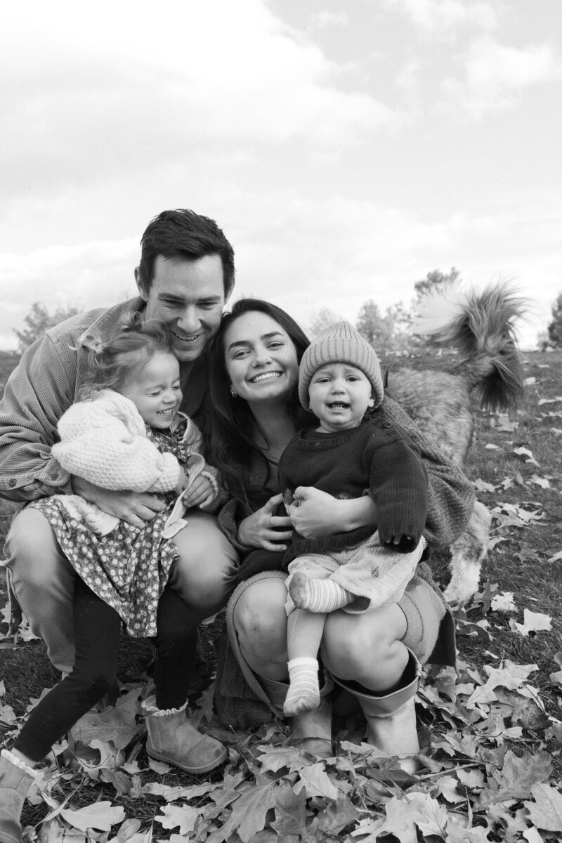 Family of 4 in grassy flower field