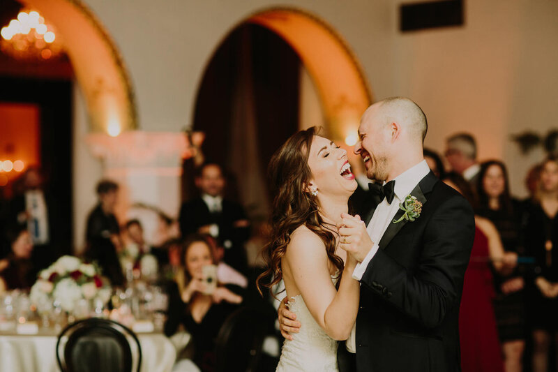 Bride and groom laugh joyfully while dancing on their wedding night