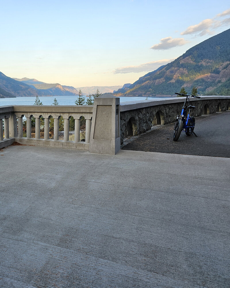 Enjoy stunning views of the river and hills of the gorge from a viewpoint with a blue E-bike at Viento State Park with The Gorge E-Bike Adventure Rentals