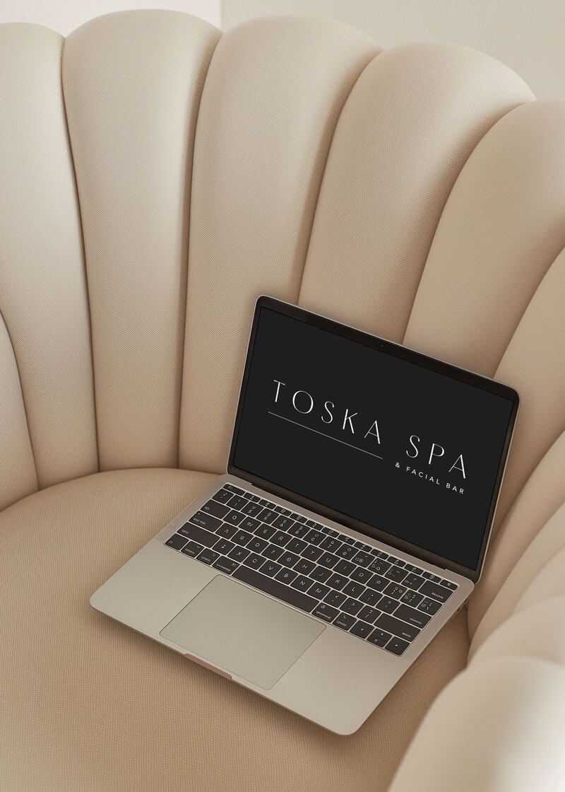Laptop screen mockup displaying Toska Spa’s brand identity including monogram and colour palette