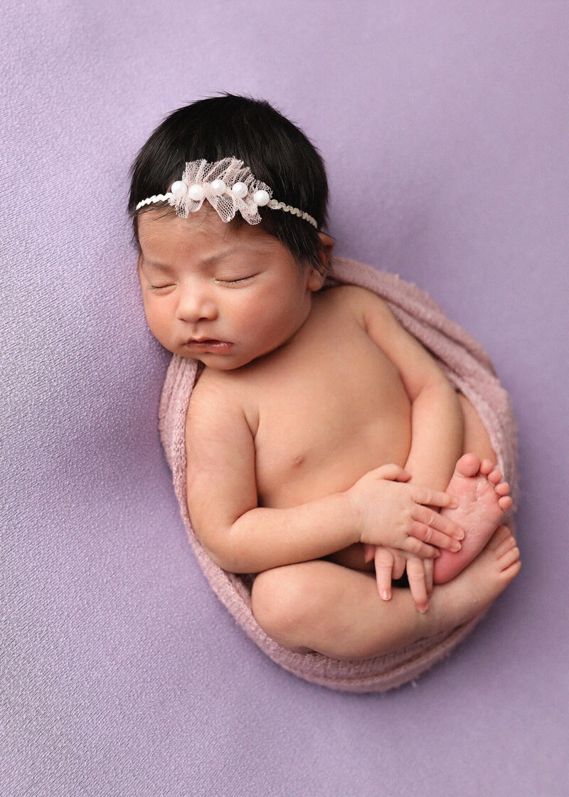 Baby sleeping comfortably  in small vintage bathtub