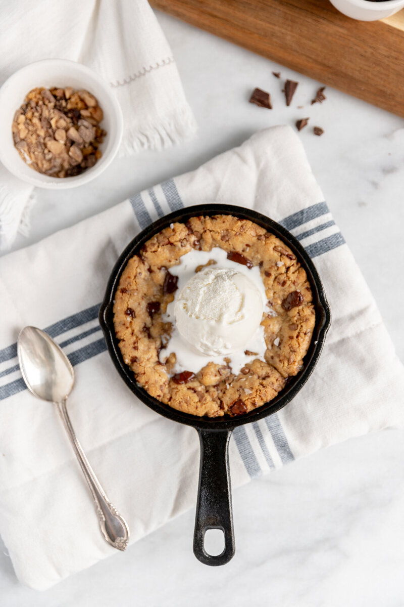 a skillet cookie topped with vanilla ice cream