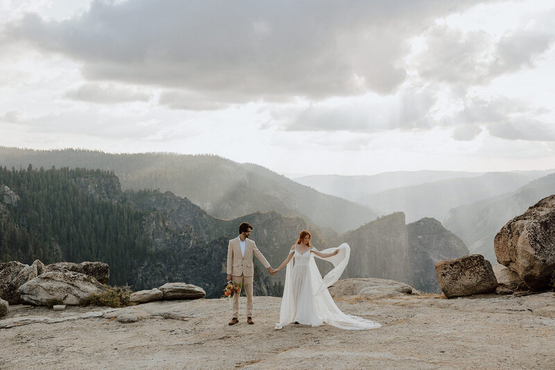 bride and groom standing side by side on a rocky overlook