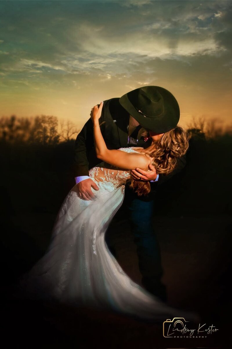 Bridal party holding sparklers around kissing bride and groom
