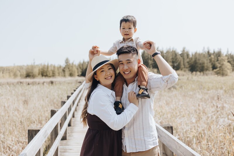 Toddler on dad's shoulder smiling