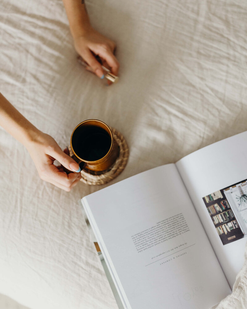 Brand and Web Design holding a coffee cup and reading a magazine  for Mindful Entrepreneurs