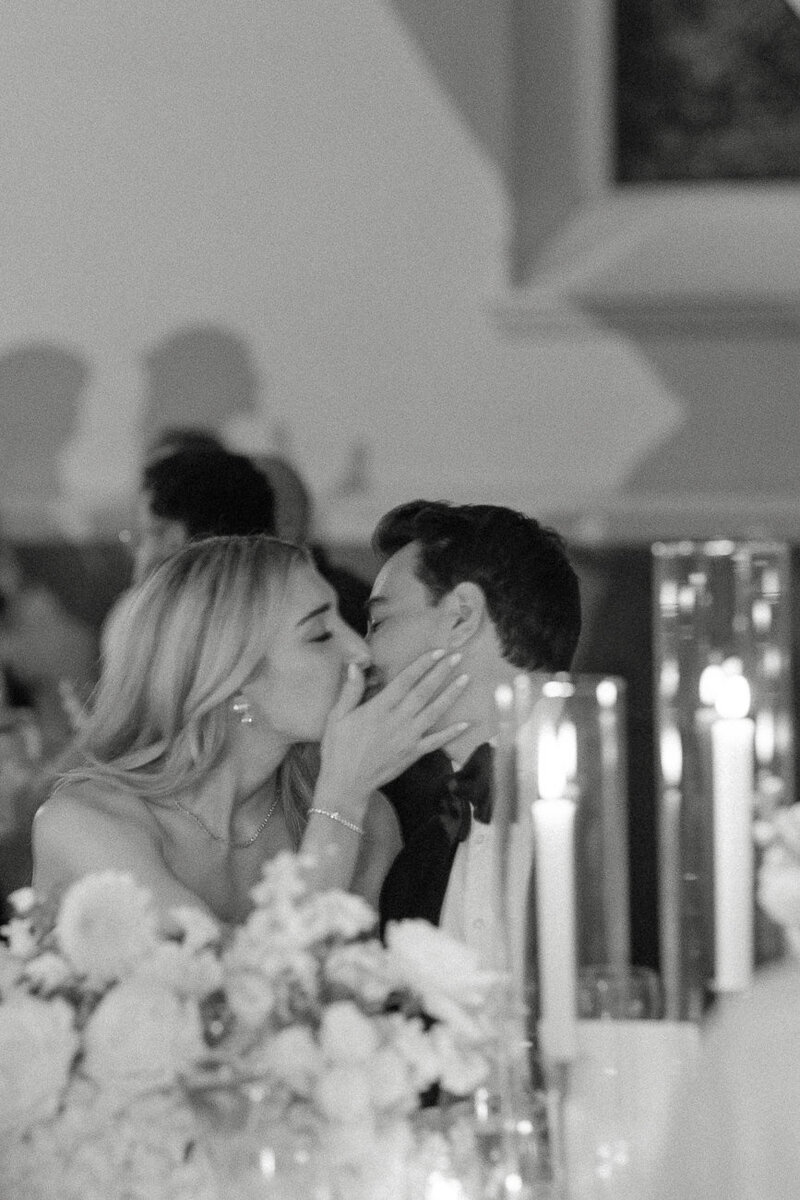 Deux amoureux s'embrassent lors de leur réception de mariage dans un ambiance tamisée. Photographe mariage montreal