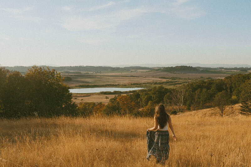 girl in sweater and overalls standing on oregon coast