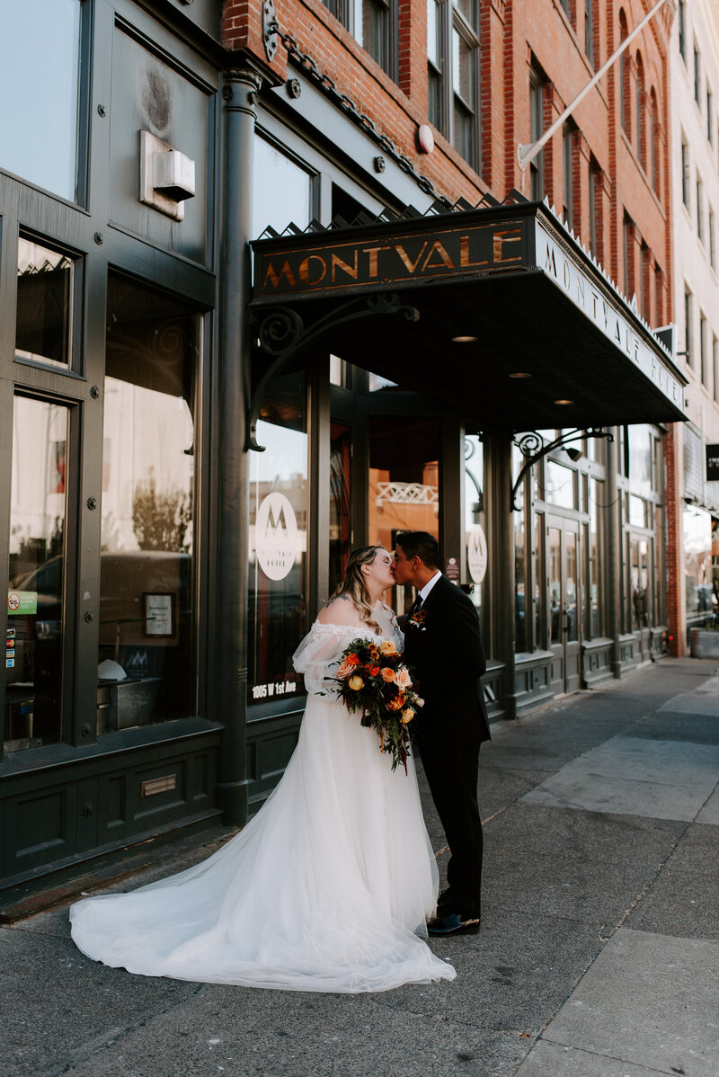 A bride and groom smile at each other in their beautiful wedding venue, Chateau Rive in downtown Spokane, Washington.