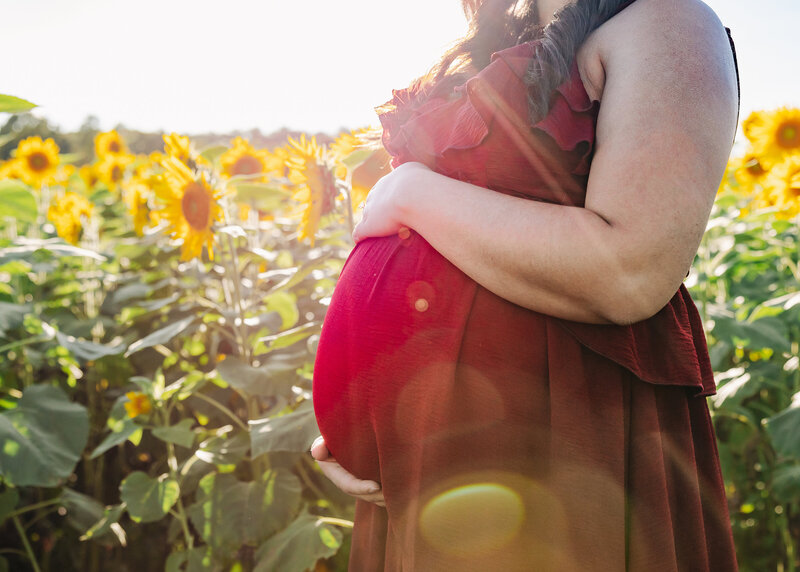Lifestyle maternity photo at a sunflower field in New Jersey.