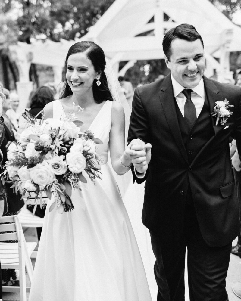 The newlyweds just got married, and they're exiting the ceremony to loud cheers from all the guests. You can hear the joy in their voices and the excited celebration in the air! At Bearpath Golf and Country Club. Captured by Top wedding photographer Toly Dzyuba Photography.