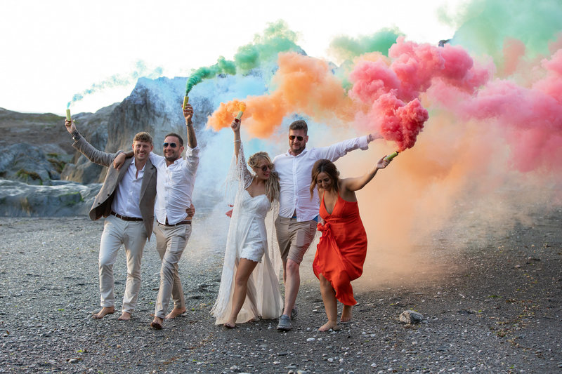 Bridal party with smoke bombs on the beach at Tunnels Beaches Devon