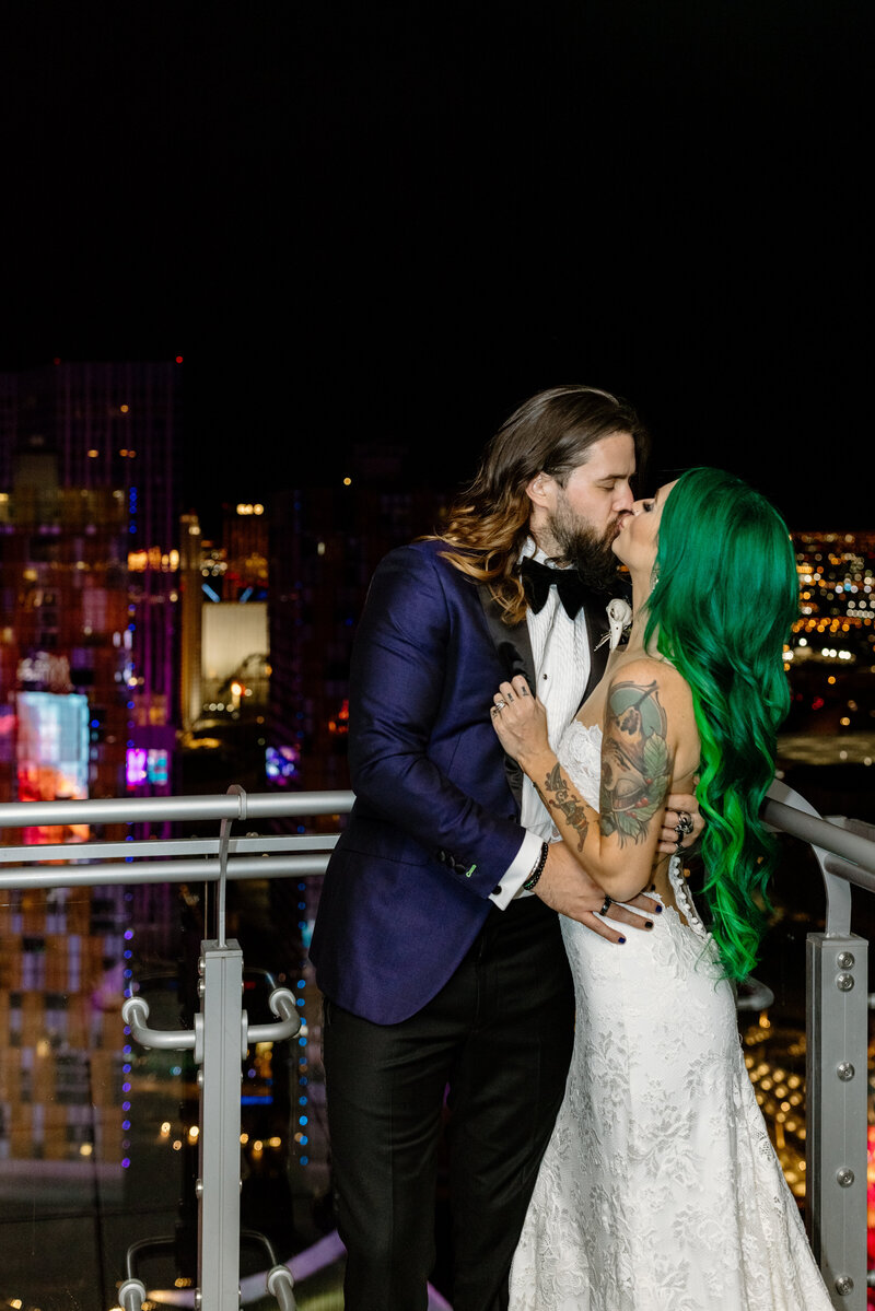 Edgy couple kissing on a balcony in wedding attire