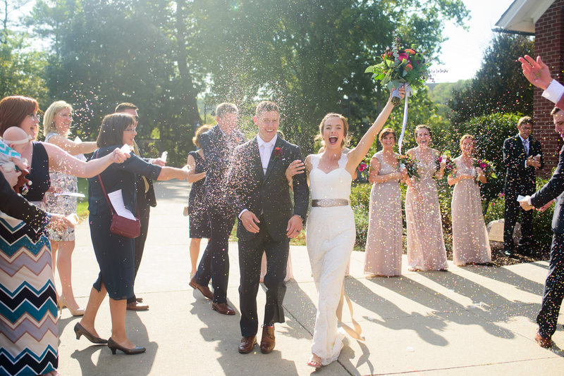 Bride and Groom exiting their chapel to guests throwing confetti