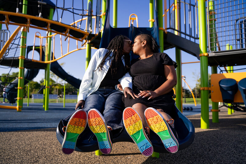 Couple kissing with rainbow soled converse on Michigan playground
