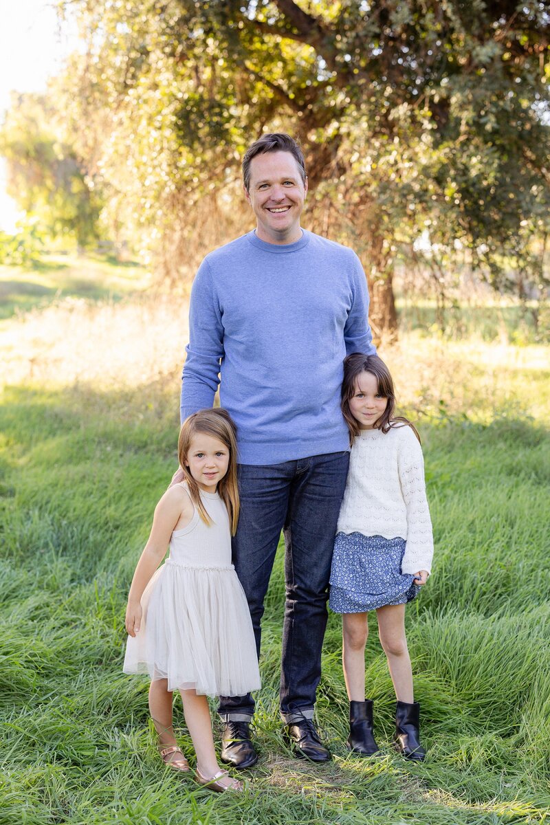 dad and daughters pose for holiday family photos
