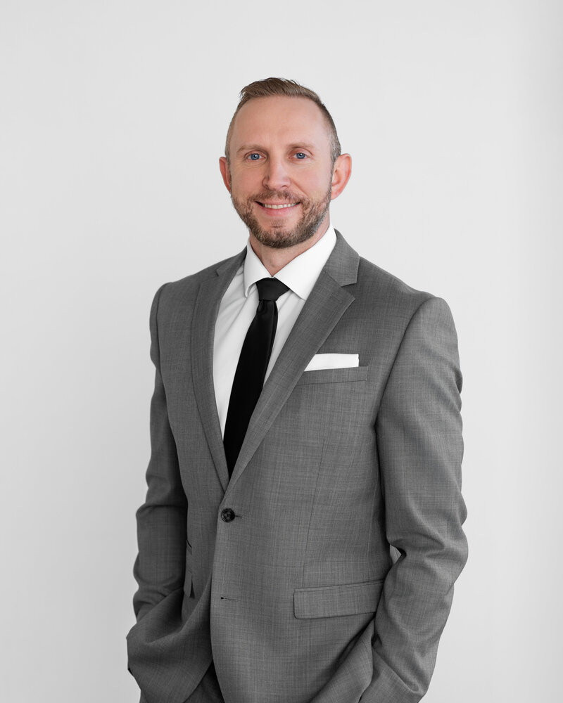 Man with his hands in his pockets takes a corporate headshot