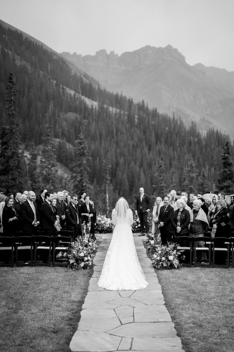 Bride walks down the aisle to the groom at a fall wedding in Telluride. 