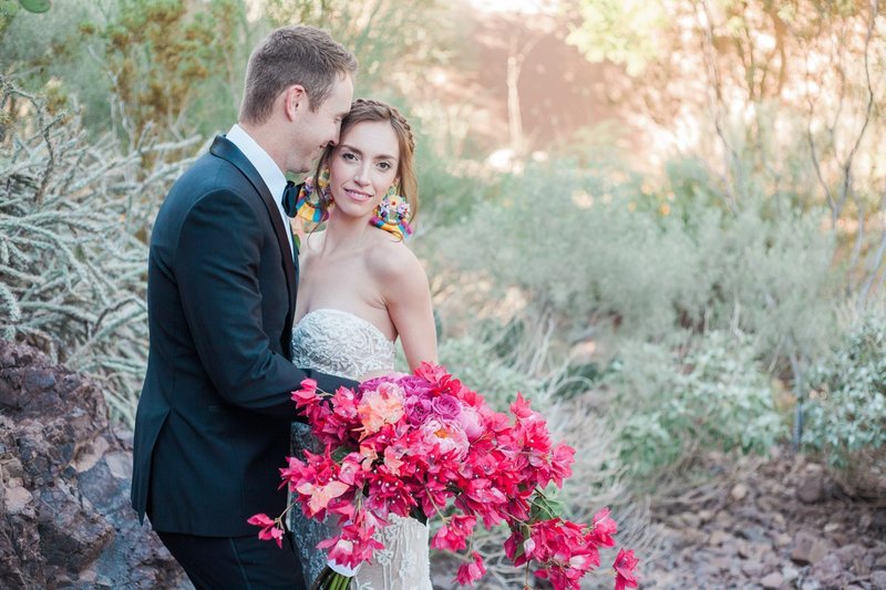 Groom-with-bride-holding-fuschia-bouquet-in-desert-wedding-by-the-Jepsons