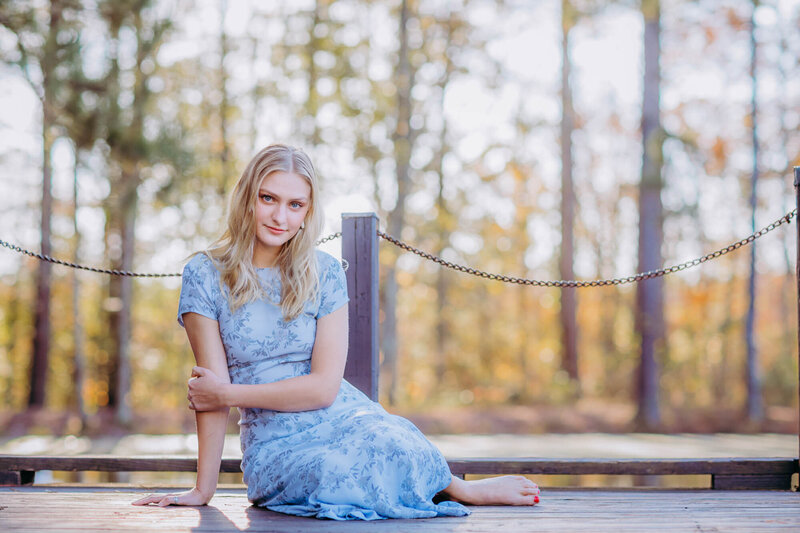 Senior portrait of a girl sitting on the dock at Line Creek Nature Reserve in Peachtree City, Georgia.