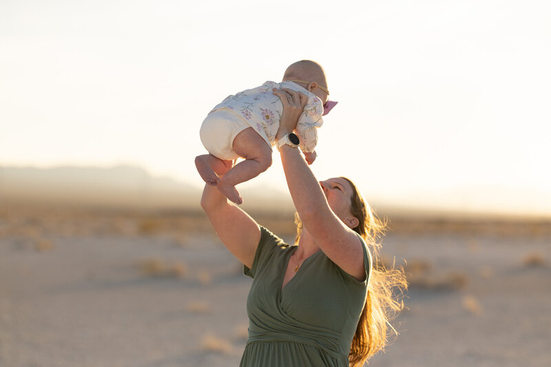 husband and wife looking lovingly at their daughter who is smiling towards the camera taken by las vegas portrait photographer alexis dean