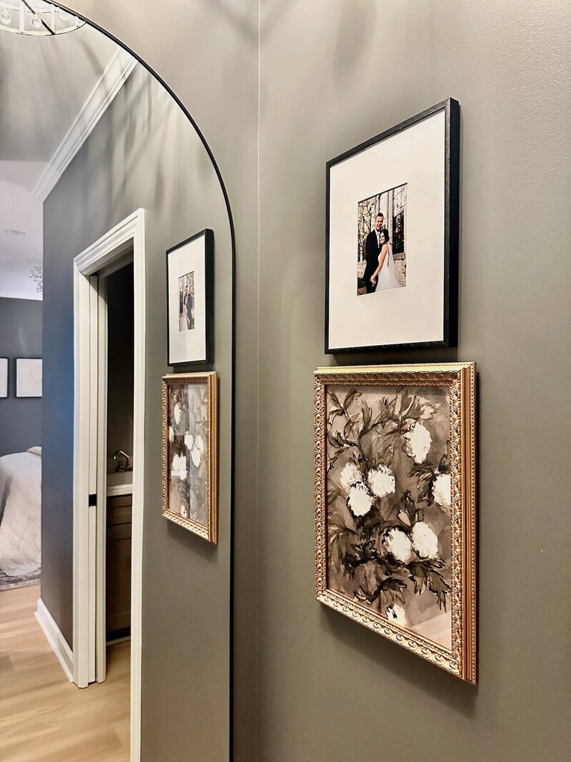 Two frames neatly arranged on a wall next to a mirror, one vintage and one modern.