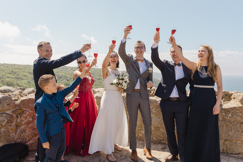 A group of guests with newlyweds toasting on Bornholm during their micro wedding in Europe