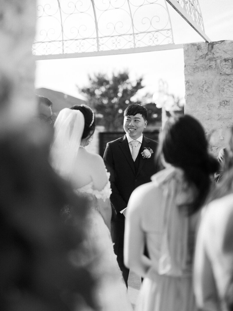 Groom laughing and smiling at his bride during ceremony