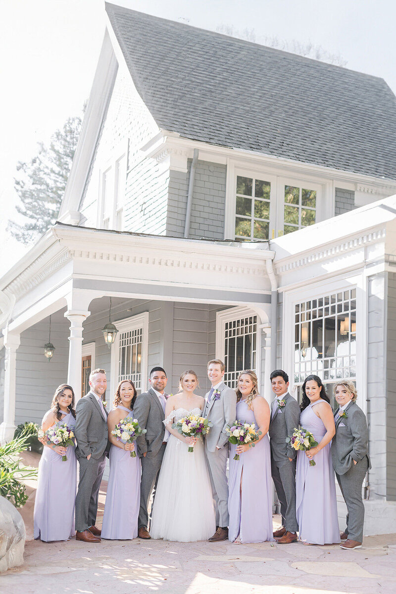 a wedding bridal party poses together in front of the Wedgewood Sequoia Mansion Wedding Venue