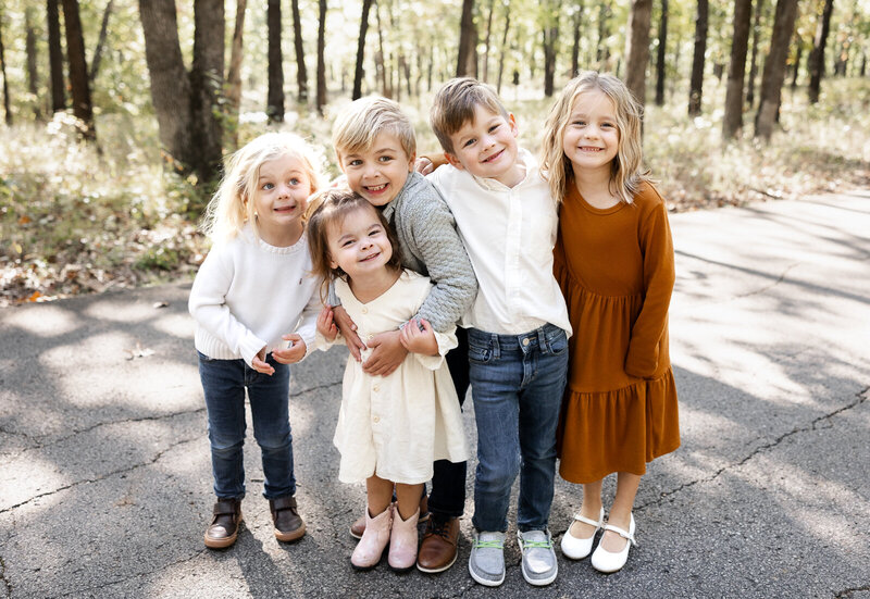Five children standing and hugging during a lifestyle cousin family portrait session with Jennifer Mosier Photography. 