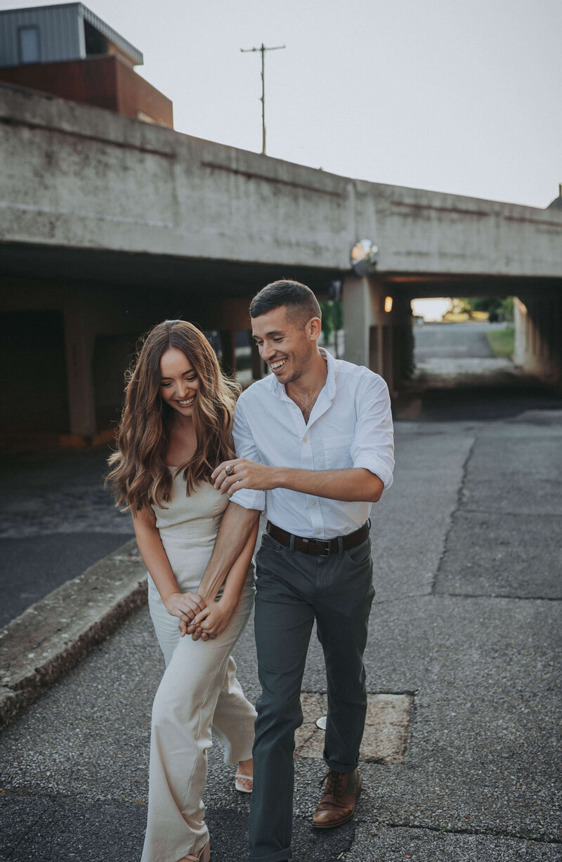 An engaged couple walks and laughs together through the South Main district in Memphis