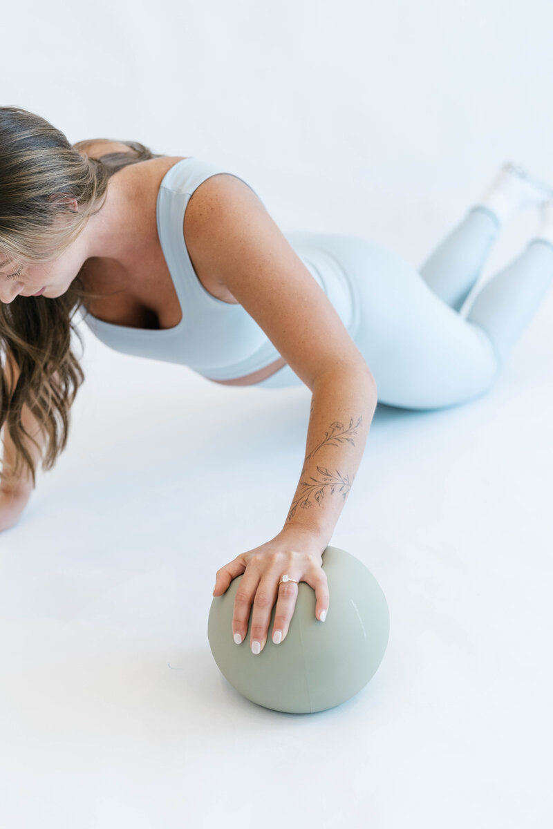 Woman doing a push up with her hand on a ball