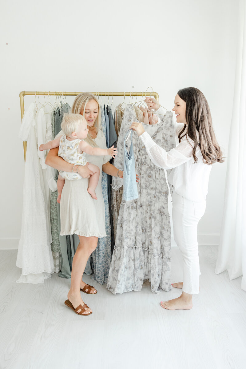 Newborn photographer, Kristin Wood, helps a mother select her portrait wardrobe while she holds her baby
