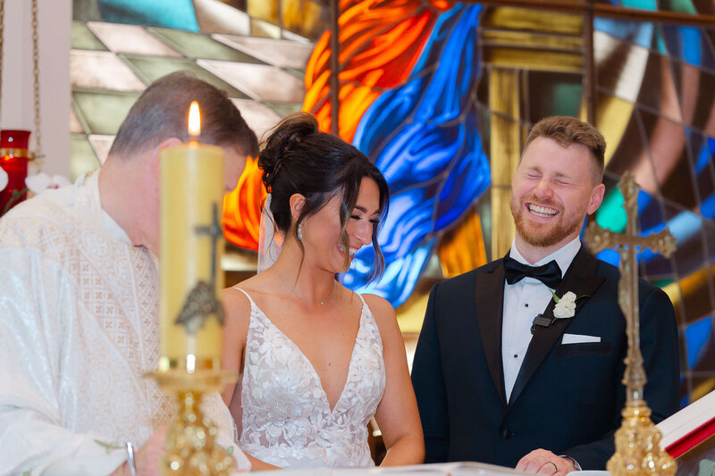 Ottawa wedding photography showing a groom laughing and smiling as he signs the church register during his wedding ceremony