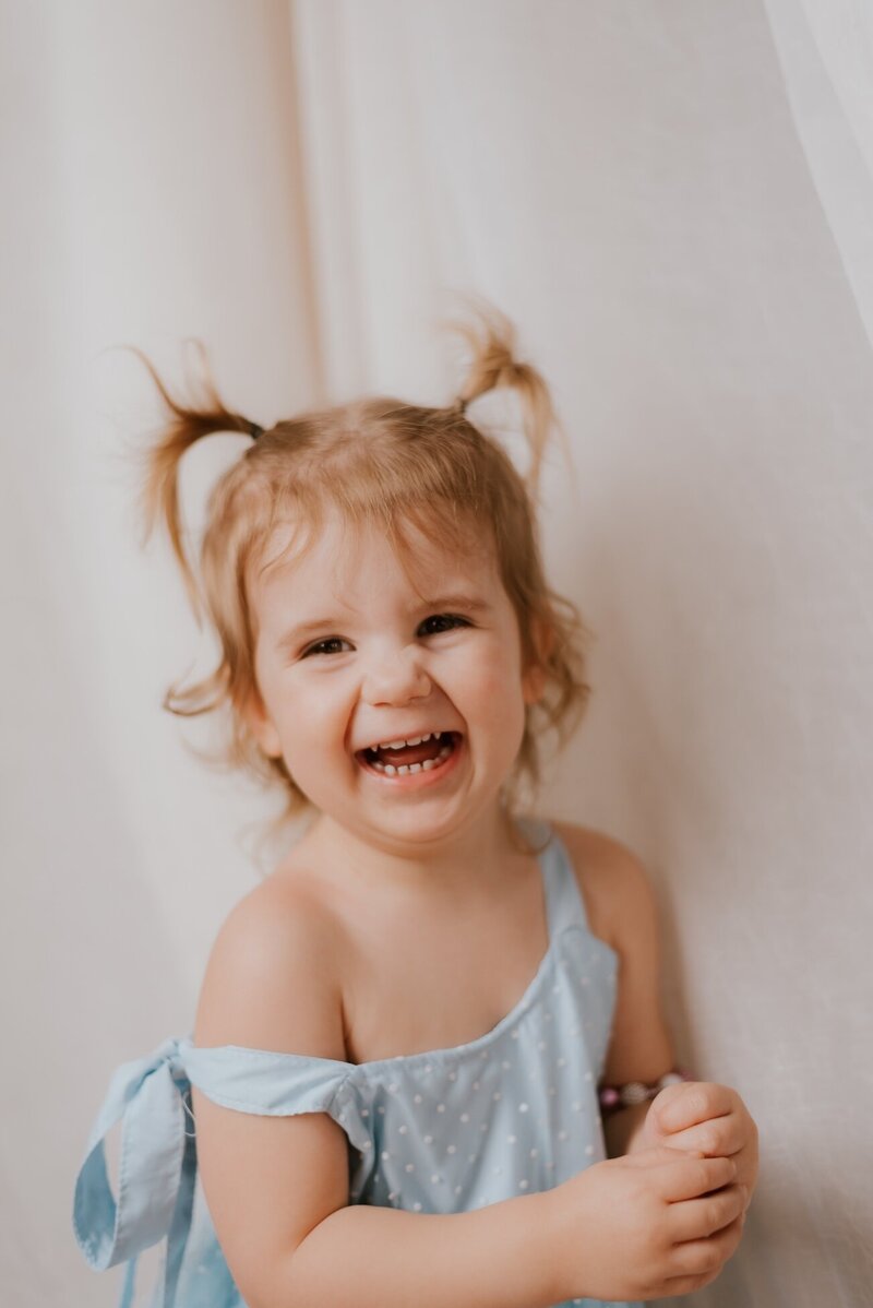 little girl poses for family photos in peoria il