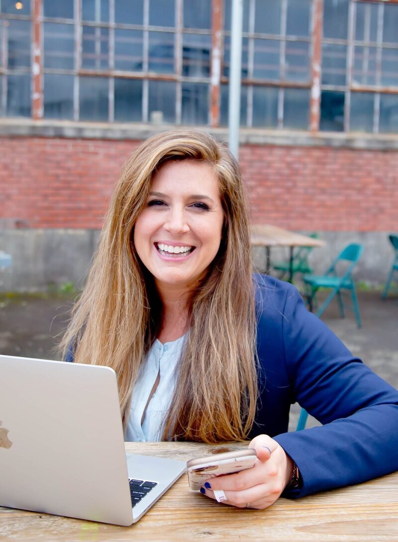 Smiling woman sits in front of her laptop thrilled with her copywriting services