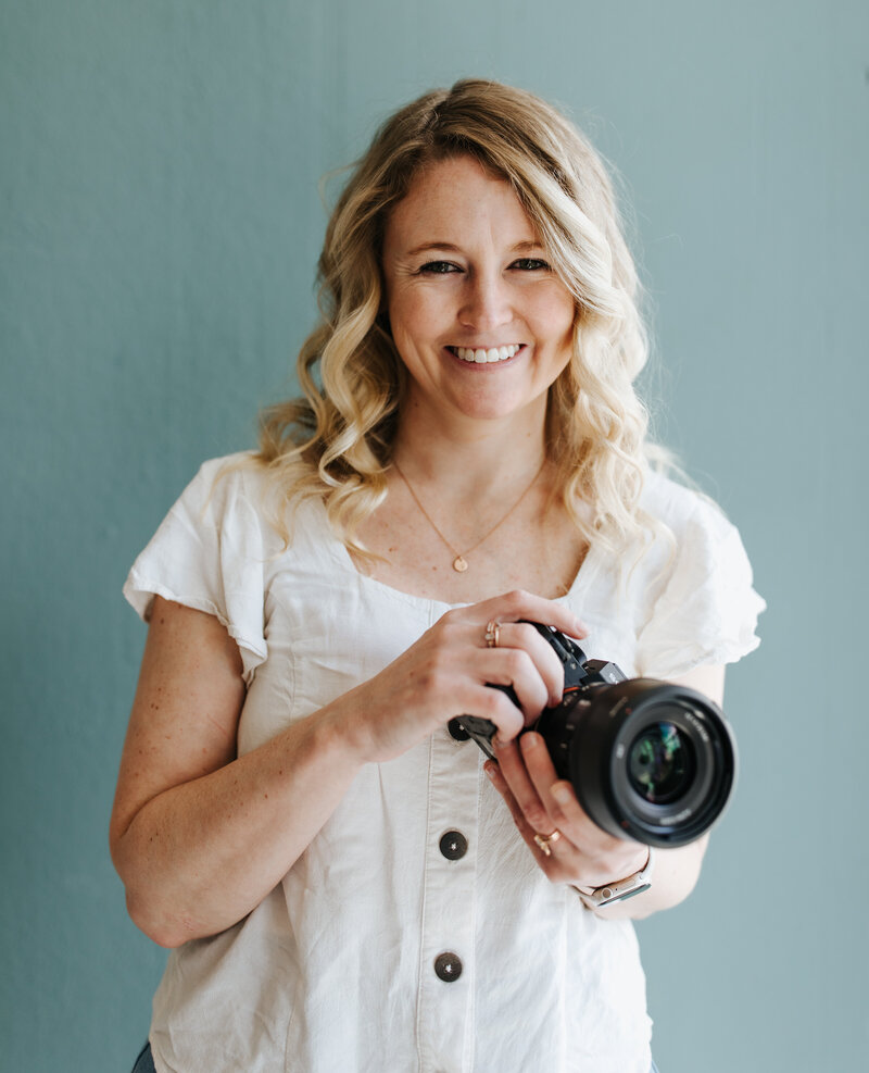 Oregon wedding and elopement photographer holding a camera and smiling