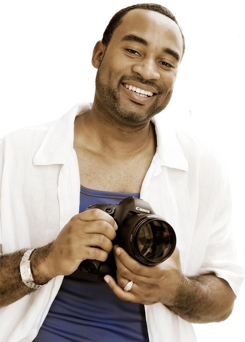 Photo of Amir smiling and holding his camera